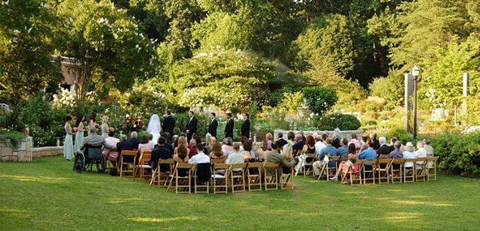 Wedding guests watch as an Atlanta couple get married outdoors